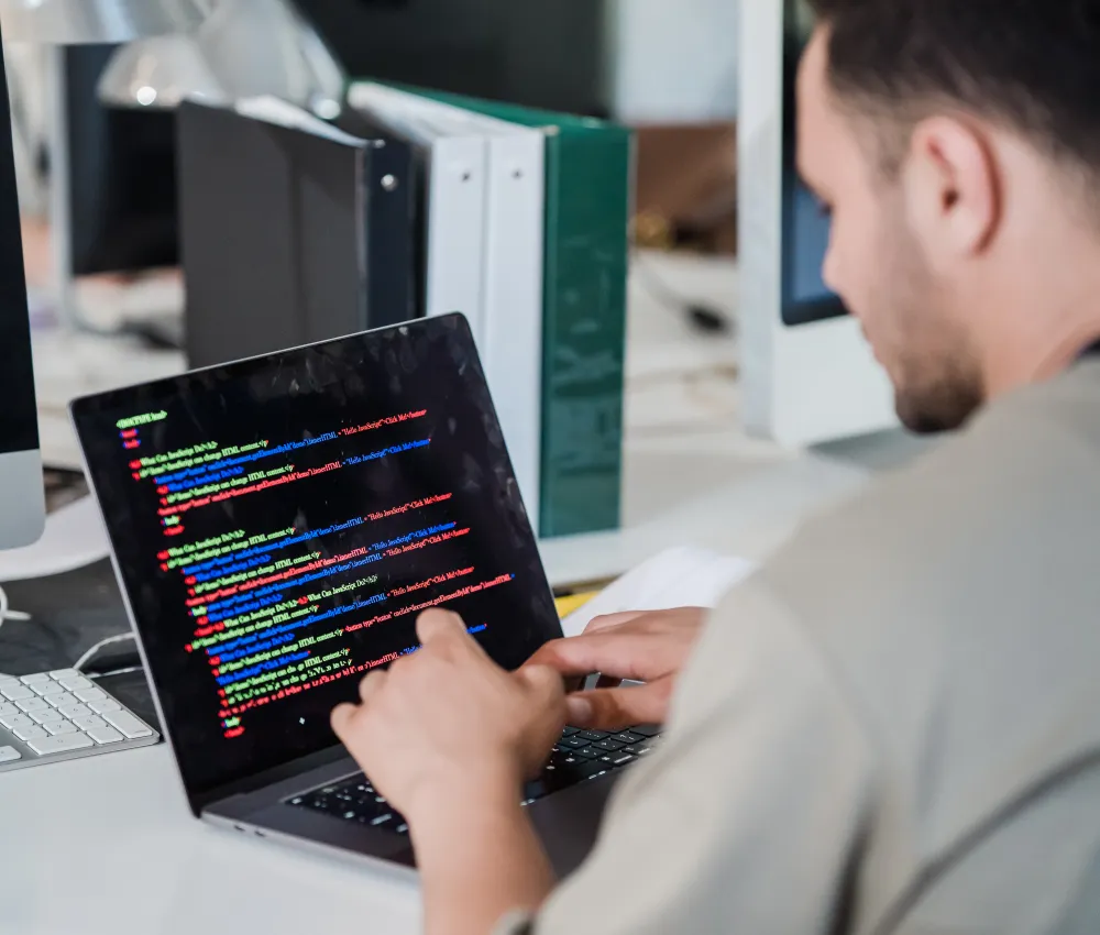 A developer working on a laptop in an office